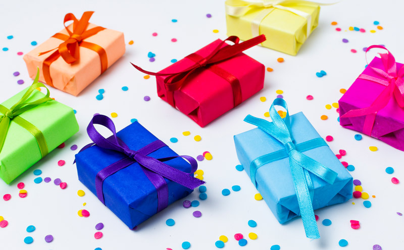 Cajas de regalo de distintos colores con lazo de color a juego